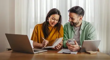 Couple smiling while checking notes